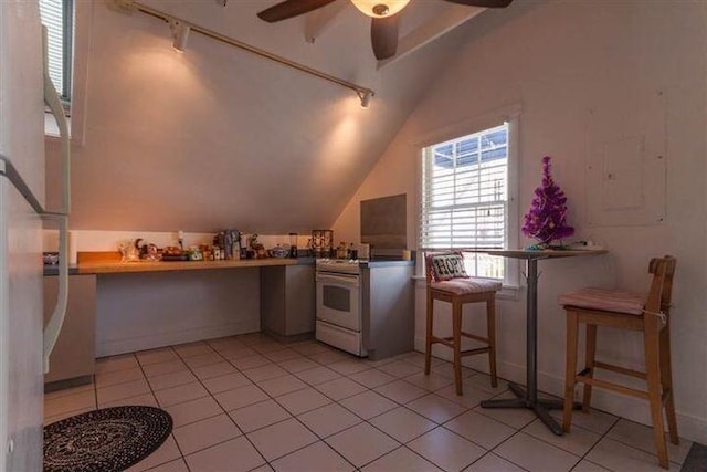 kitchen with electric stove, vaulted ceiling, ceiling fan, and light tile patterned flooring