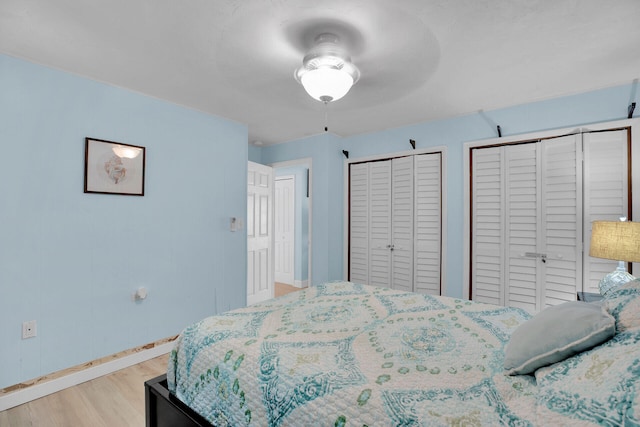 bedroom featuring hardwood / wood-style flooring and two closets