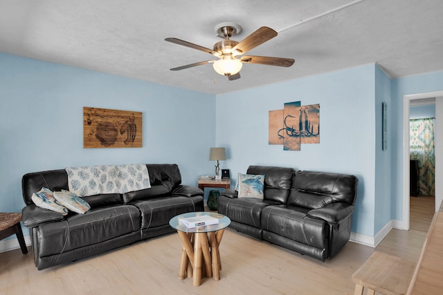 living room featuring hardwood / wood-style flooring, ceiling fan, and a textured ceiling