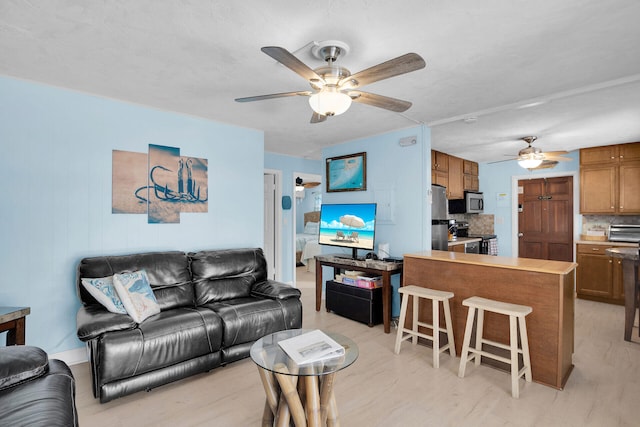 living room featuring ceiling fan and light wood-type flooring