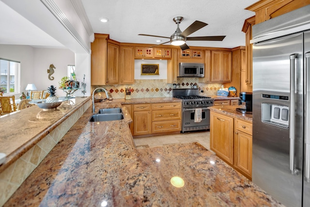 175 Galleon Rd, Islamorada, FL 33036 - kitchen with premium appliances, a ceiling fan, light stone counters, decorative backsplash, and a peninsula