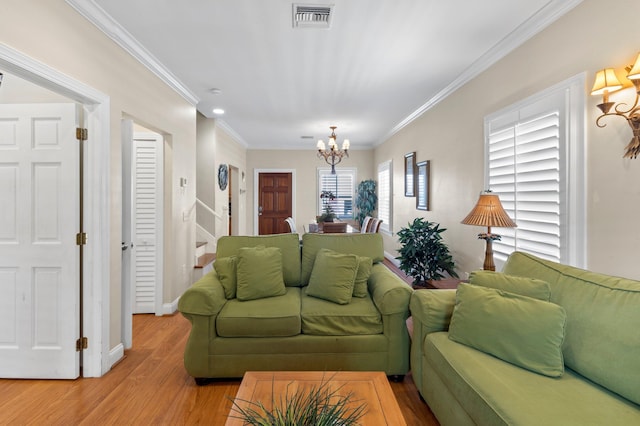 living room featuring a chandelier, visible vents, baseboards, light wood-style floors, and ornamental molding