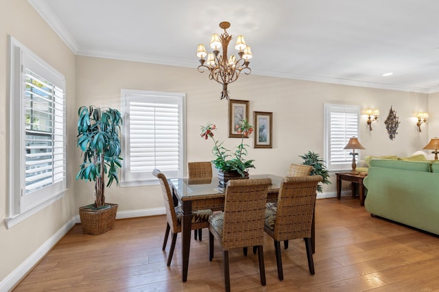 dining space featuring ornamental molding, a wealth of natural light, and light wood-style floors