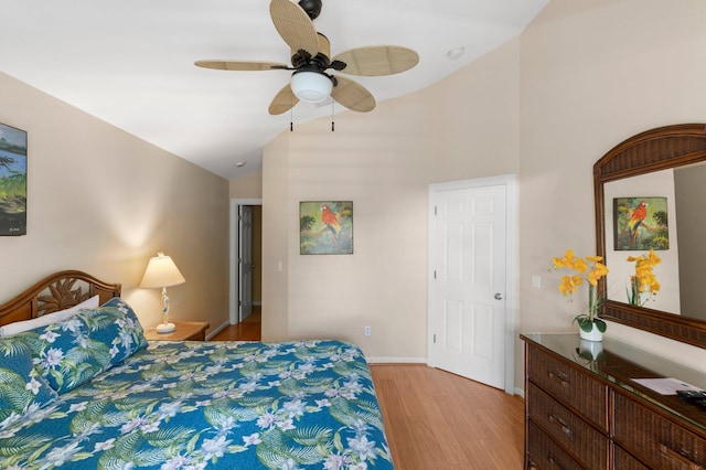 bedroom with high vaulted ceiling, light wood-style flooring, baseboards, and ceiling fan