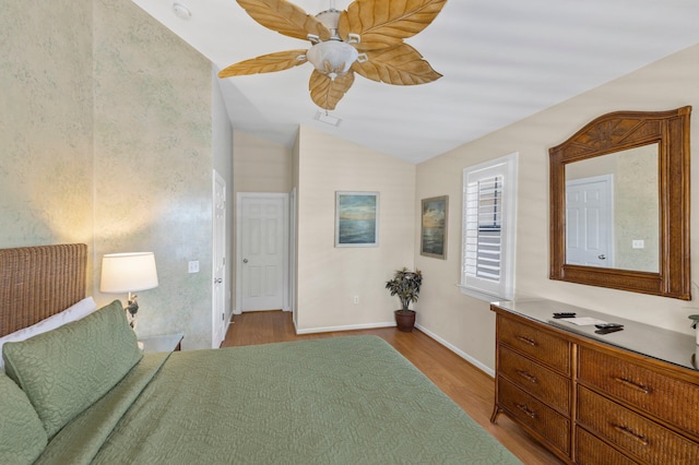 bedroom featuring visible vents, ceiling fan, vaulted ceiling, wood finished floors, and baseboards