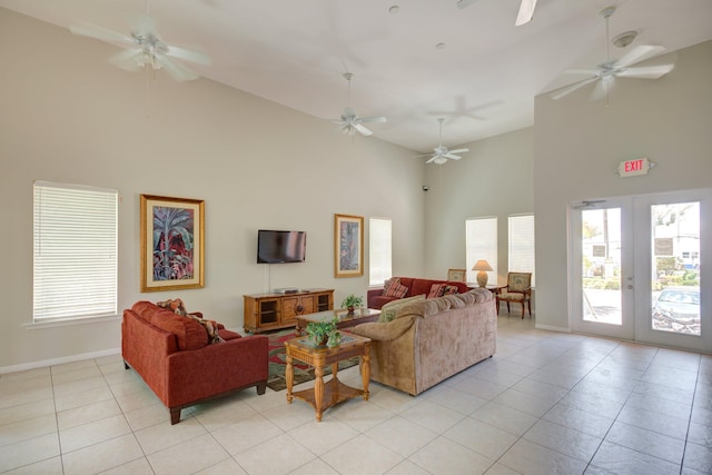 living area featuring french doors, a ceiling fan, light tile patterned flooring, high vaulted ceiling, and baseboards