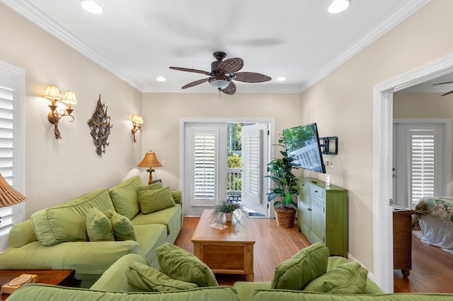 living room with ornamental molding, a healthy amount of sunlight, and wood finished floors