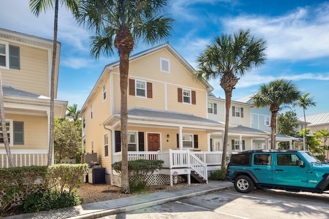 view of front of home with a porch and uncovered parking