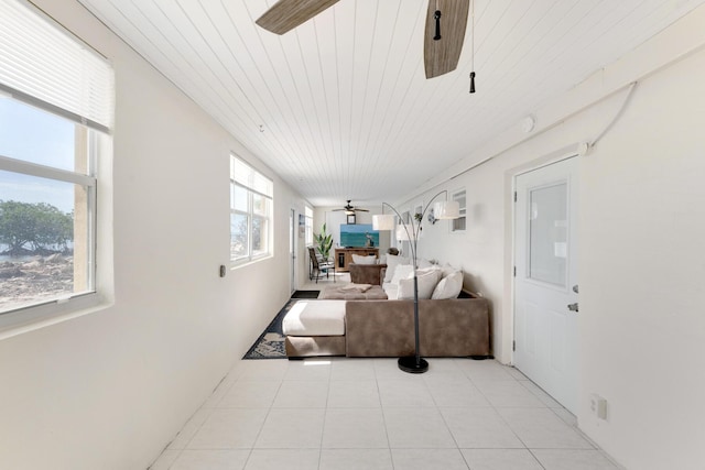 living room with light tile patterned floors, wood ceiling, and ceiling fan