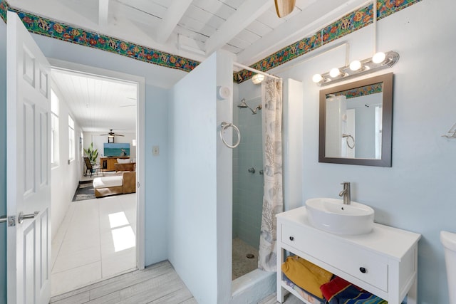 bathroom featuring vanity, ceiling fan, beam ceiling, and walk in shower