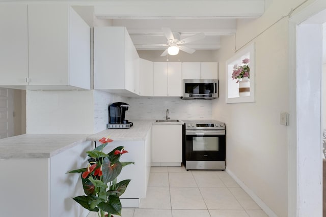 kitchen featuring light tile patterned flooring, tasteful backsplash, sink, white cabinets, and stainless steel appliances