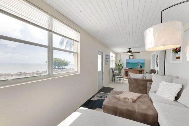 living room with a water view, wood ceiling, and light tile patterned flooring