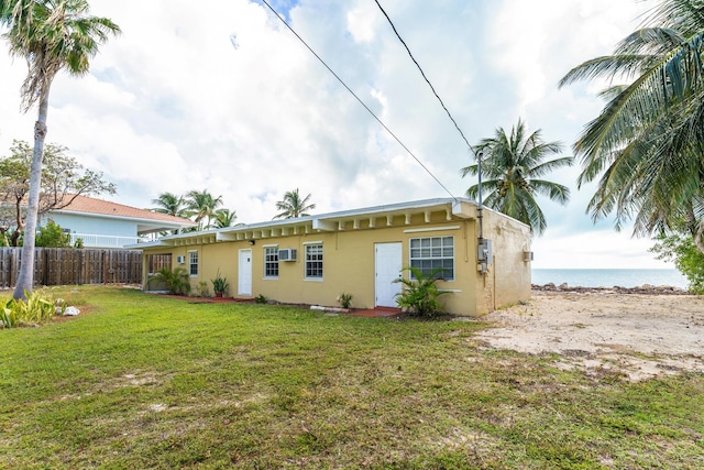 back of house with a yard and a water view