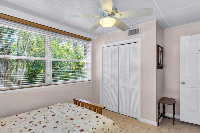 bedroom with light tile patterned floors, a closet, and ceiling fan