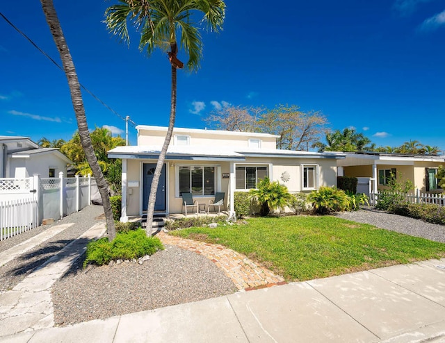 view of front of house featuring a front yard, fence, a porch, and stucco siding