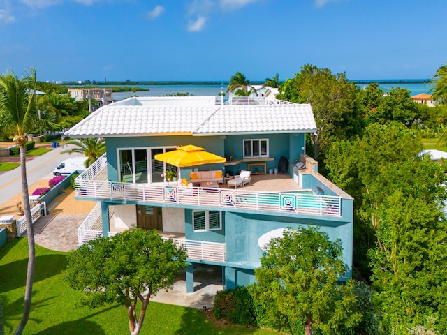 rear view of house featuring a patio, a water view, and an outdoor hangout area