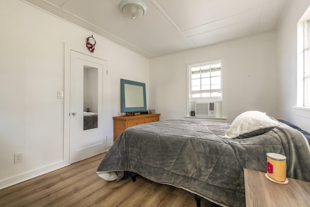 bedroom with wood-type flooring and cooling unit