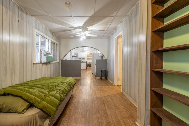 bedroom featuring light hardwood / wood-style floors and wood walls