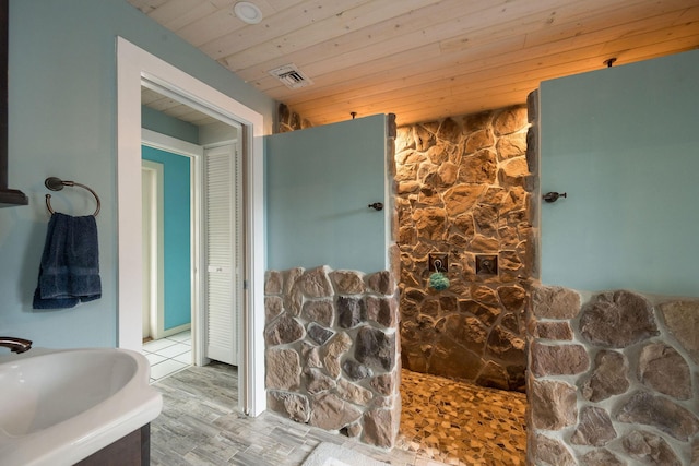 bathroom with wood ceiling, visible vents, and a sink