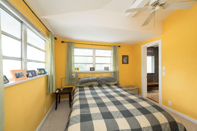 carpeted bedroom featuring a ceiling fan, lofted ceiling, multiple windows, and baseboards