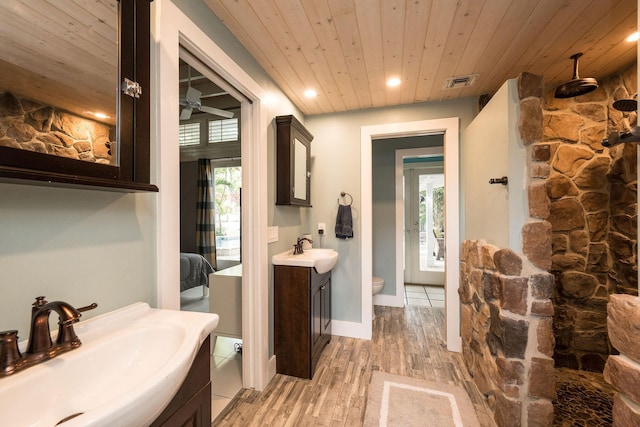 full bath with two vanities, wood ceiling, visible vents, and a sink