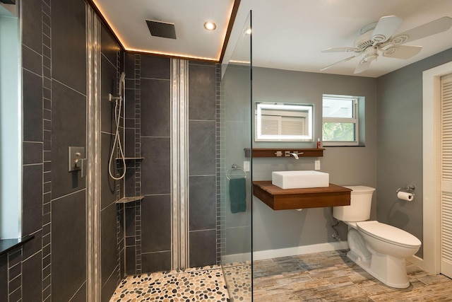 bathroom with a stall shower, visible vents, a sink, and toilet