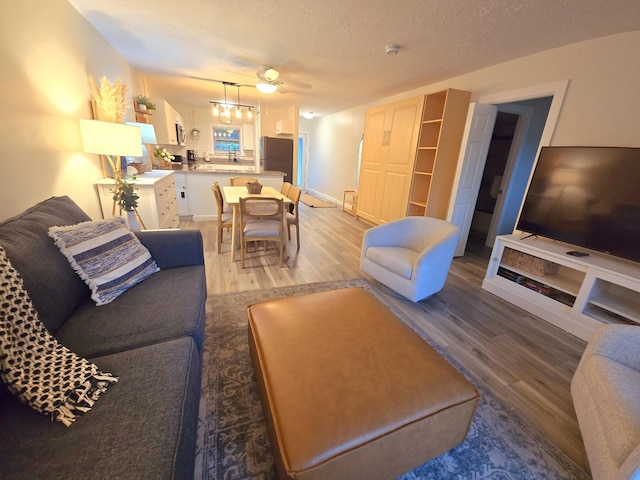 living area featuring light wood-style floors and a textured ceiling