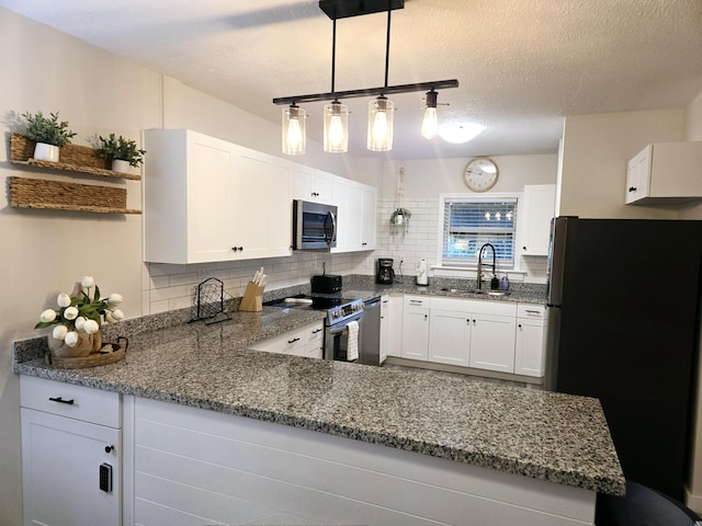 kitchen featuring decorative light fixtures, stainless steel appliances, backsplash, white cabinetry, and a sink