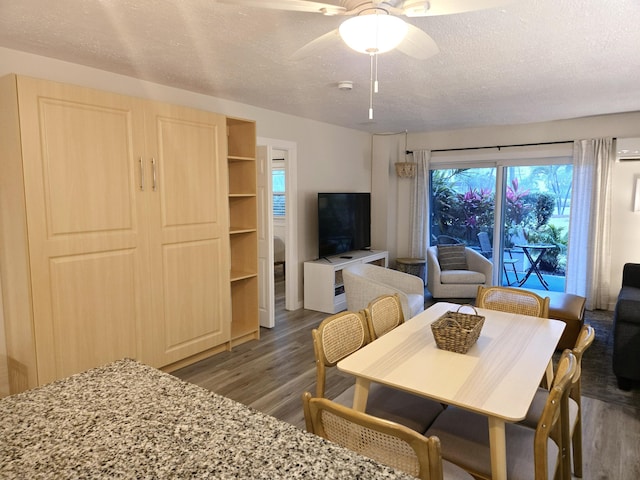 dining room featuring dark wood-style floors, ceiling fan, a textured ceiling, and a wall mounted air conditioner