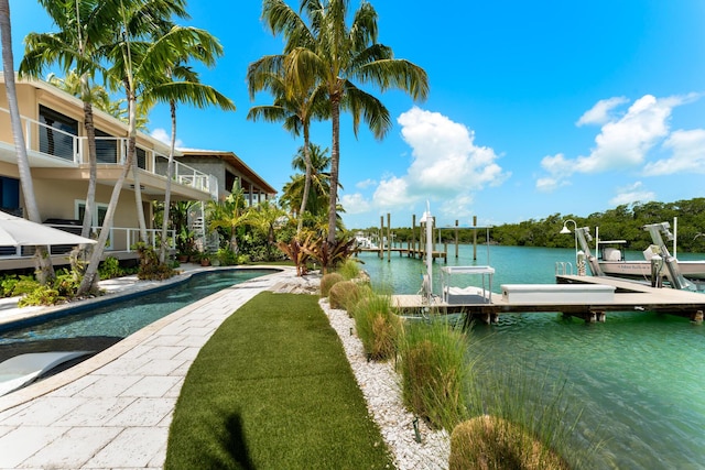 dock area with boat lift, a water view, and an outdoor pool