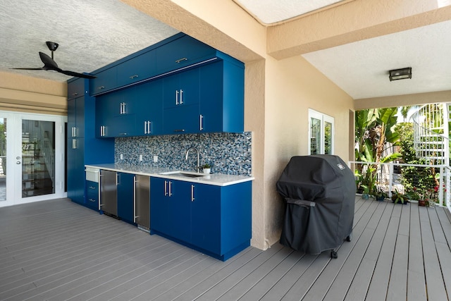deck with a sink, grilling area, and a ceiling fan