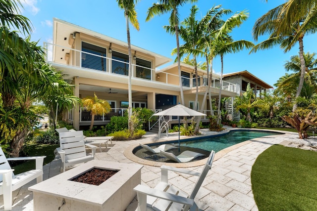 swimming pool with a fire pit and a patio