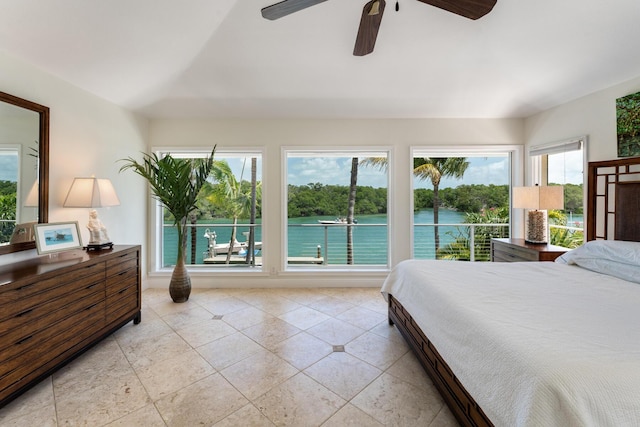 tiled bedroom featuring multiple windows, a water view, and a ceiling fan