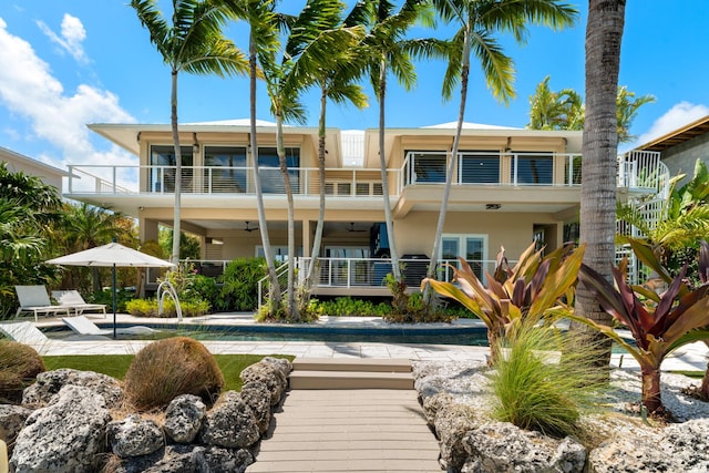 rear view of property featuring a balcony, stucco siding, and a patio