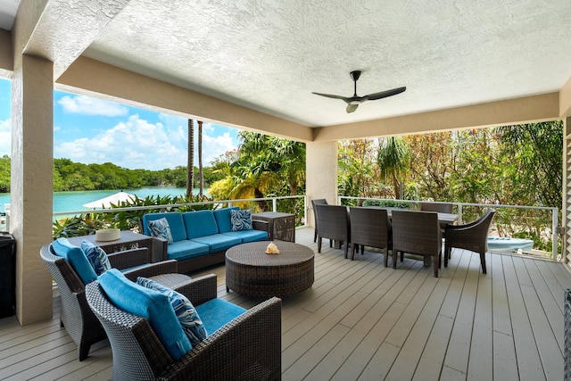 wooden deck featuring outdoor lounge area, a ceiling fan, a water view, and outdoor dining area
