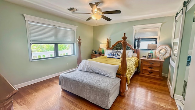 164 Tortuga Ln, Cudjoe, FL 33042 - bedroom featuring wood finished floors, a barn door, visible vents, and multiple windows