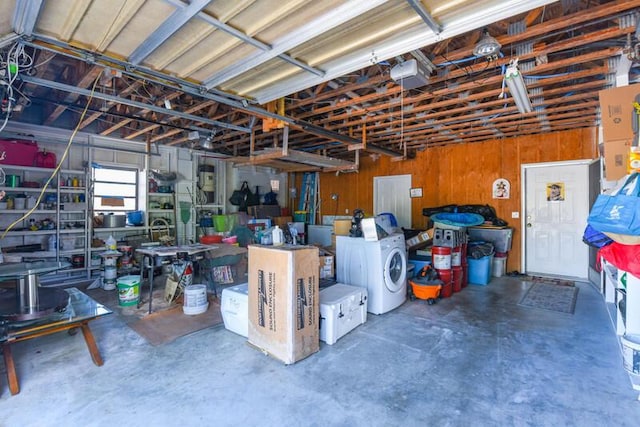 garage featuring a garage door opener, washer / dryer, and a workshop area
