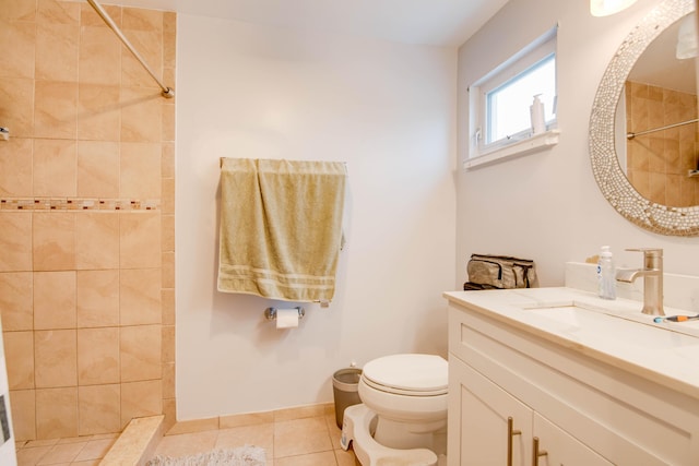 bathroom with tile patterned flooring, vanity, toilet, and tiled shower