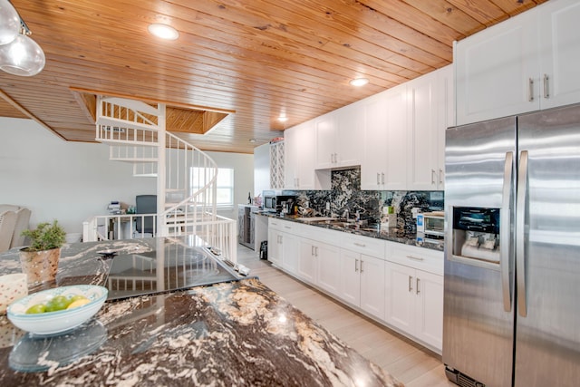 kitchen featuring white cabinets, stainless steel fridge, backsplash, and decorative light fixtures