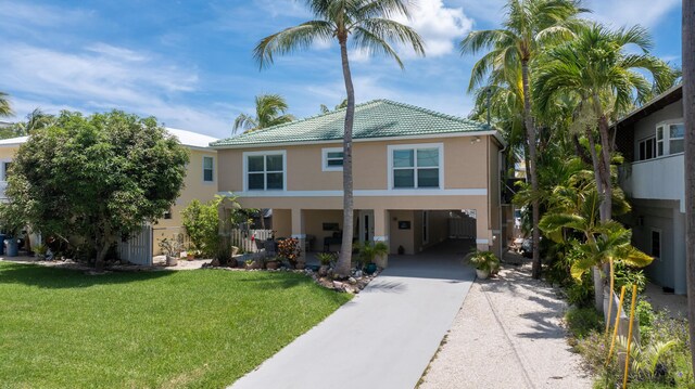 19 N Dr, Key Largo, FL 33037 - view of front of house with a carport, stucco siding, concrete driveway, a front lawn, and a tiled roof