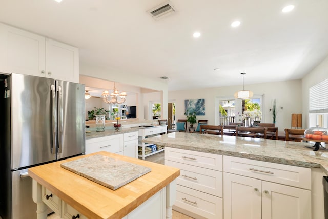 19 N Dr, Key Largo, FL 33037 - kitchen featuring freestanding refrigerator, butcher block counters, a peninsula, white cabinets, and recessed lighting