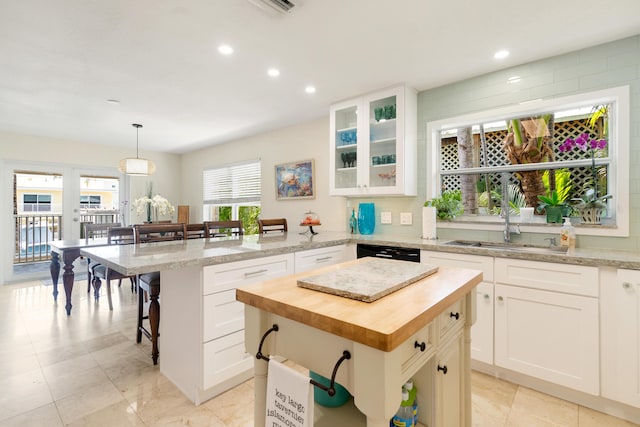 19 N Dr, Key Largo, FL 33037 - kitchen with butcher block counters, a breakfast bar, a peninsula, recessed lighting, and glass insert cabinets