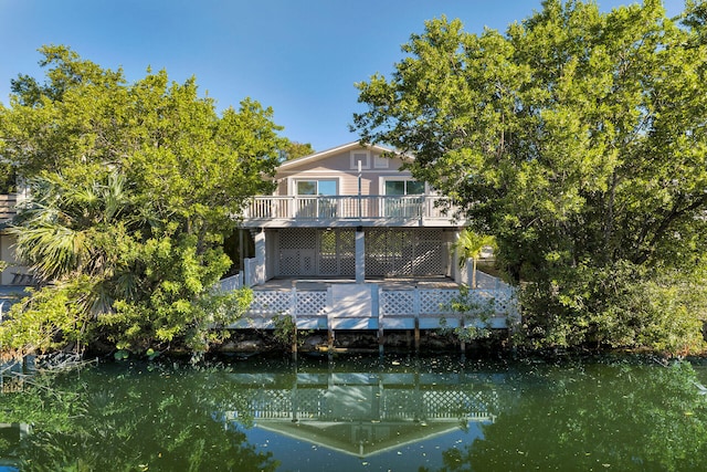 rear view of property with a balcony and a water view