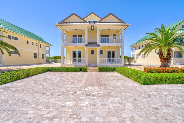 2394 Coco Plum Dr Unit 2, Marathon, FL 33050 - view of front facade featuring a balcony, french doors, a metal roof, a standing seam roof, and stucco siding