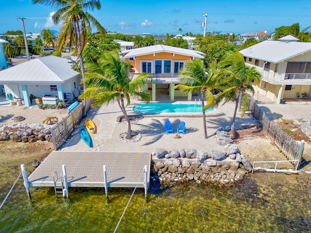 rear view of property with a fenced in pool, a patio, a balcony, and a water view