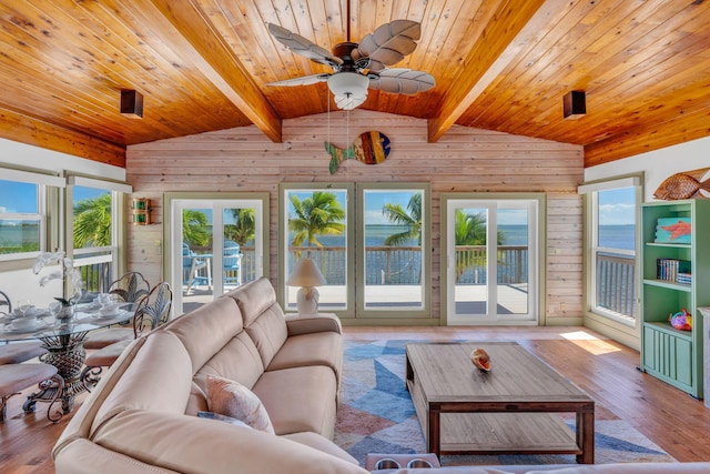 unfurnished sunroom with ceiling fan, a water view, vaulted ceiling with beams, and wood ceiling