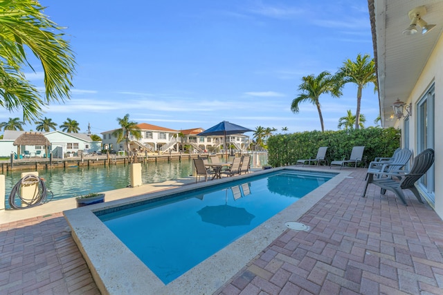 view of swimming pool featuring a patio area and a water view