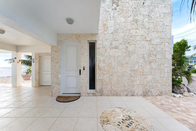 tiled entrance foyer with a water view