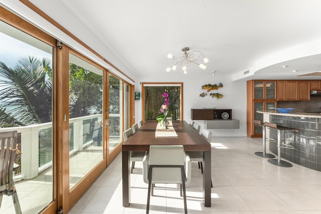 tiled dining room with a notable chandelier