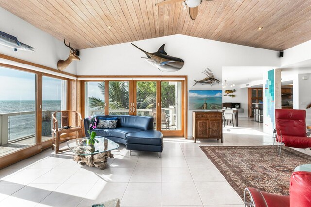 tiled living room with a water view, ceiling fan, wood ceiling, and vaulted ceiling